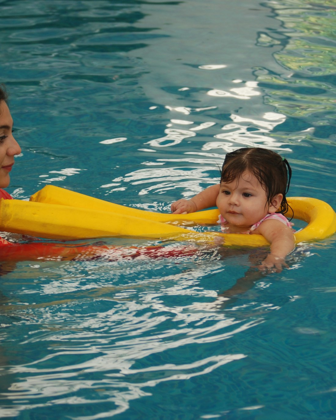 A Coastal Aquatics instructor guiding a child during a swimming lesson